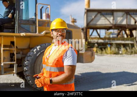 Giovane lavoratore vestito con attrezzatura di sicurezza all'interno della fabbrica Foto Stock