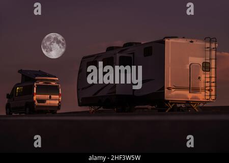 Full Moon Night in un parco RV. Camper moderno Van Motorhome e Trailer di viaggio. Veicoli da diporto e tema camping. Foto Stock