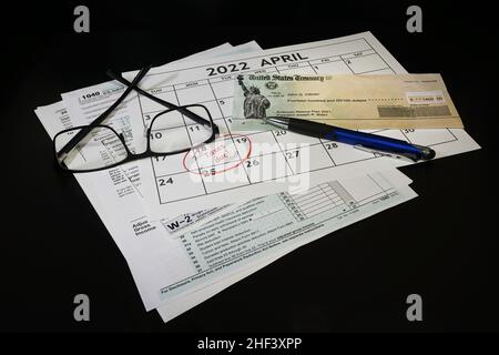 Concetto di 2021 documenti di preparazione fiscale e calendario con aprile 18th cerchiato su sfondo nero. Foto Stock