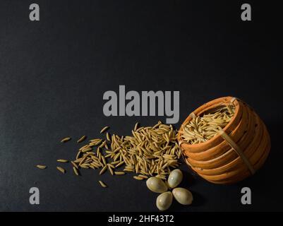 makar sankranti, tema laxmi puja con semi di risone, pentola di riso su sfondo scuro con tutti gli elementi essenziali. indiano bengalese cultura locale tradizionale cel Foto Stock