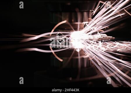 Scintille brillanti dovute al contatto di metallo su una macchina utensile Foto Stock