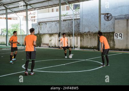 quattro giocatori del futsal si esercitano passando la sfera Foto Stock