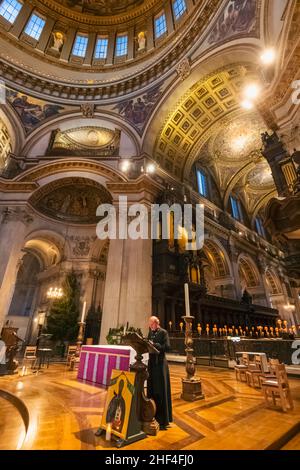 Inghilterra, Londra, Cattedrale di St. Paul, sacerdote che offre preghiere mattutine con il Duomo e il Quire sullo sfondo Foto Stock