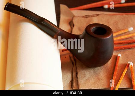 Fumando tubo con fiammiferi e lettera bruciata e vecchi rotoli. Banco d'epoca dall'atmosfera suggestiva Foto Stock