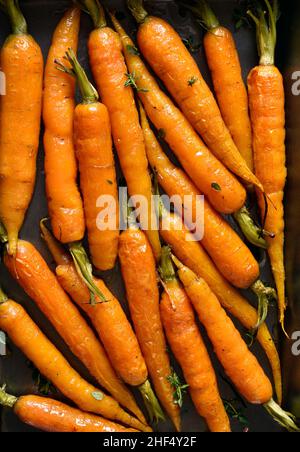 Vista ravvicinata delle carote glassate al miele arrostite. Vista dall'alto, piatto Foto Stock