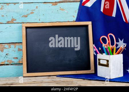 Scritta in bianco ardesia dalla bandiera australiana e l'organizer da tavolo contro la parete blu con spazio copia Foto Stock