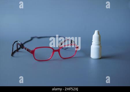 primo piano del flacone e dell'occhiale di caduta su nero Foto Stock