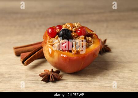 Concetto di gustoso cibo con mela al forno su sfondo di legno Foto Stock