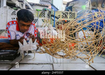 Un artigiano creatore di costumi da ballo leone (Barongsai) e drago (Liong), ispeziona le sue creazioni all'interno della sua casa prima delle celebrazioni del Capodanno lunare Foto Stock