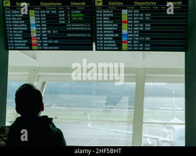 Un uomo che guarda informazioni a bordo di partenza e controlla il suo volo in aeroporto per viaggiare in Europa. Visualizzazione digitale degli orari per il passeggero Foto Stock