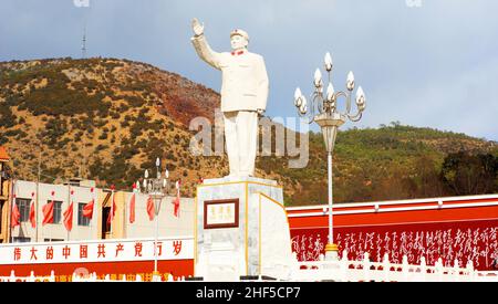 Statua di MAO, con lo slogan sul muro: 'Viva il grande partito comunista della Cina' a Lijiang il 18 2012 febbraio. MAO, uomo di stato Foto Stock