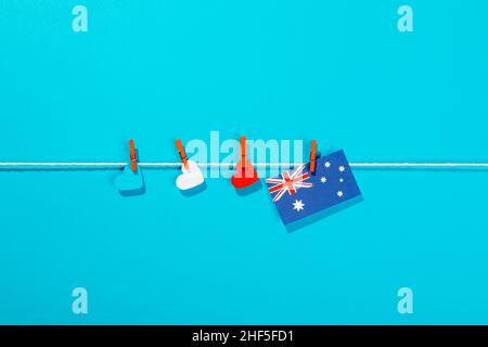 Australia bandiera e carte a forma di cuore su clothesline isolato su sfondo blu con spazio copia Foto Stock