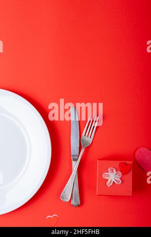 Vista dall'alto dell'impostazione del luogo da regalo di San Valentino su sfondo rosso, spazio di copia Foto Stock