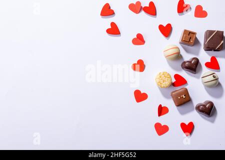 Cioccolatini a forma di cuore rosso da spazio copia su sfondo bianco Foto Stock