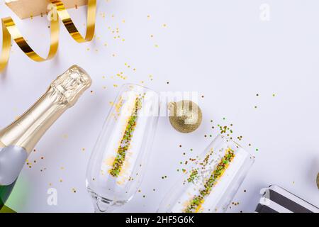 Vista dall'alto della bottiglia di champagne con confetti in flauti da decorazione bauble Foto Stock