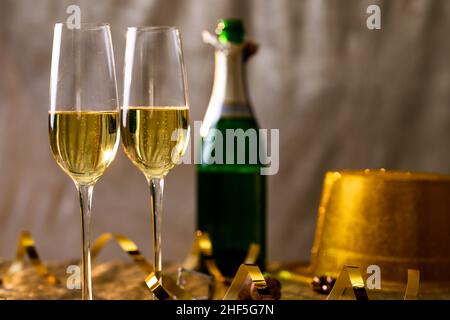 Primo piano di champagne in flauti con nastro d'oro in bottiglia sul tavolo Foto Stock