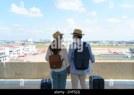 Coppia di viaggiatori asiatici in attesa treno alla stazione ferroviaria vicino aeroporto a Bangkok, Thailandia, concetto di viaggio e trasporto Foto Stock