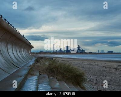 Un orizzonte industriale; l’acciaieria abbandonata di Redcar incorniciata da un muro marino ricorrente. Foto Stock