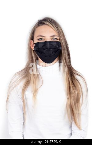 Concetto di medicina e assistenza sanitaria. Primo piano giovane e lungo capelli brunette donna ritratto con maschera medicina nera sul suo viso isolato su bianco backgroun Foto Stock