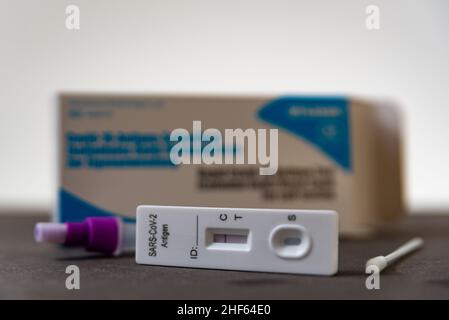 Un test rapido dell'antigene per SARS-COV-2 o Covid è osservato su una tabella con bastoncino da tampone nasale durante un rapido aumento della domanda dovuto alla variante Omicron di Cov Foto Stock