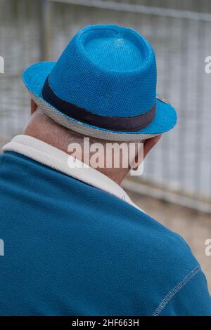 Uomo maturo che indossa un pile blu con un cappello blu abbinato. Foto Stock