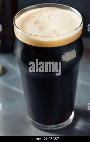 Rinfrescante birra Irish Stout fredda in un bicchiere di pinta Foto Stock
