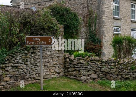 Cropton, UK - 5th ottobre 2019: Segnaletica stradale per Kelby Forest Cabins nel pittoresco villaggio di campagna, Cropton, Inghilterra. Direzione Foto Stock