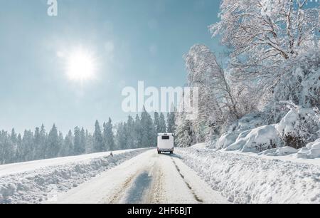 Camper su una strada innevata in montagna Foto Stock