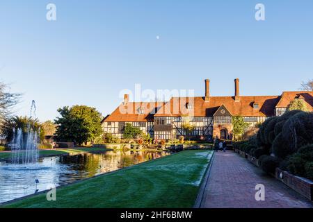 Vista posteriore dell'esterno dell'iconico edificio del laboratorio e riflessi nel canale Jellicoe, RHS Garden, Wisley, Surrey in inverno in una giornata di sole Foto Stock