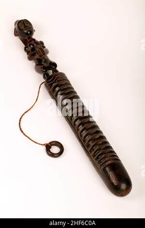 Guiro africano decorativamente scolpito con una figura alla testa. Raschiatore circolare collegato con lo spago.camera forata sul retro per la risonanza. Foto Stock