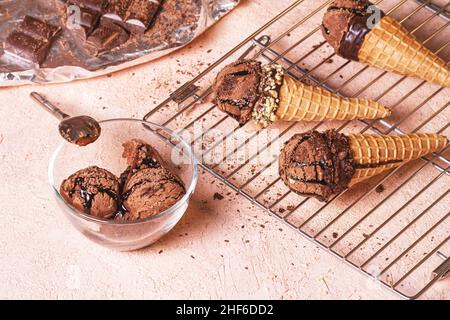 Gelato al cioccolato su una rastrelliera metallica con cucchiaio di acciaio inossidabile, fuoco selettivo, primo piano Foto Stock