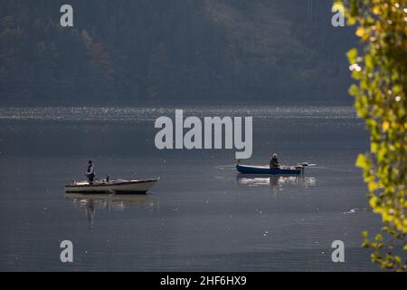 Due pescatori sulle loro barche sul lago Millstatt, Carinzia, Austria, Europa Foto Stock