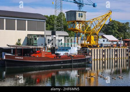 Waltrop, Renania settentrionale-Vestfalia, Germania, parch. Di navi, seggiovia e serratura Waltrop. Qui la nave 'Cerberus' di 100 anni al molo del porto nel museo industriale Oberwasser LWL nave ascensore Henrichenburg. Le quattro strutture di discesa al ramo del canale Reno-Herne dal canale Dortmund-EMS sono conosciute come il parco di blocco di Waltrop. L'unico sistema di sollevamento in funzione è il nuovo blocco, costruito nel 1989 tra il vecchio blocco dell'albero e il nuovo sollevatore. Foto Stock