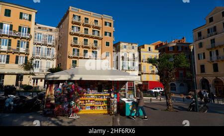 Grecia, Isole greche, Isole IONIE, Corfù, Corfù, Centro storico, chiosco (Periptero) accanto al Liston, dietro di esso edifici storici della città vecchia, cielo blu, luce del mattino Foto Stock