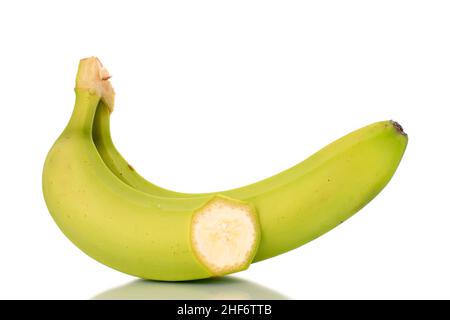 Una banana verde organica intera e mezza, macrofibata su bianco. Foto Stock