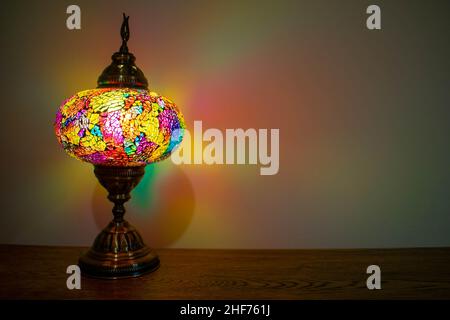 Lampada tradizionale in vetro colorato turco/marocchino, bronzo antico con vetro multicolore che emette luce in molte direzioni causando un effetto mistico Foto Stock