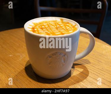 Una tazza di starbucks su un tavolo con sopra una tazza di caffè