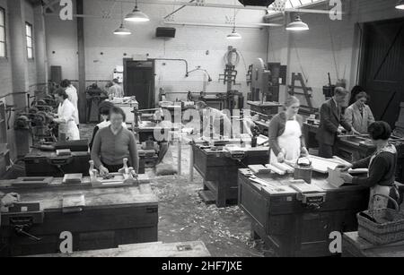 1936, storico, Signore in una classe di lavorazione del legno, mostrando loro a banchi di lavoro e un istruttore maschile aiutando uno di loro, South East Essex Technical College Essex, Inghilterra, Regno Unito. Foto Stock