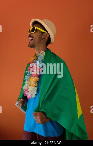 Uomo nero in costume per il carnevale con bandiera del brasile isolato su  sfondo arancione Foto stock - Alamy