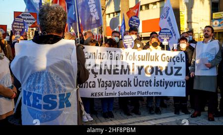 Izmir, Turchia. 14th Jan 2022. La piattaforma Izmir della KESK (Confederazione dei sindacati dei dipendenti pubblici) ha protestato contro l'alto tasso di inflazione in Turchia e ha gridato: "Non possiamo sopravvivere, vogliamo salari sufficienti per una vita umana!” La piattaforma ha evidenziato la differenza tra i calcoli dell'Istituto statistico turco (TUIK) e del Gruppo di ricerca sull'inflazione (ENAG). Dopo il comunicato stampa, hanno bruciato i loro libri paga in dimostrazione per protestare le loro difficoltà finanziarie da aumento dei prezzi di elettricità, gas naturale, combustibile, trasporto e cibo. Credit: İdil Toffolo/Alamy Live News Foto Stock