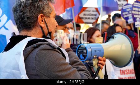 Izmir, Turchia. 14th Jan 2022. La piattaforma Izmir della KESK (Confederazione dei sindacati dei dipendenti pubblici) ha protestato contro l'alto tasso di inflazione in Turchia e ha gridato: "Non possiamo sopravvivere, vogliamo salari sufficienti per una vita umana!” La piattaforma ha evidenziato la differenza tra i calcoli dell'Istituto statistico turco (TUIK) e del Gruppo di ricerca sull'inflazione (ENAG). Dopo il comunicato stampa, hanno bruciato i loro libri paga in dimostrazione per protestare le loro difficoltà finanziarie da aumento dei prezzi di elettricità, gas naturale, combustibile, trasporto e cibo. Credit: İdil Toffolo/Alamy Live News Foto Stock