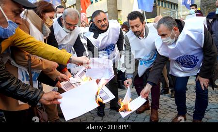 Izmir, Turchia. 14th Jan 2022. La piattaforma Izmir della KESK (Confederazione dei sindacati dei dipendenti pubblici) ha protestato contro l'alto tasso di inflazione in Turchia e ha gridato: "Non possiamo sopravvivere, vogliamo salari sufficienti per una vita umana!” La piattaforma ha evidenziato la differenza tra i calcoli dell'Istituto statistico turco (TUIK) e del Gruppo di ricerca sull'inflazione (ENAG). Dopo il comunicato stampa, hanno bruciato i loro libri paga in dimostrazione per protestare le loro difficoltà finanziarie da aumento dei prezzi di elettricità, gas naturale, combustibile, trasporto e cibo. Credit: İdil Toffolo/Alamy Live News Foto Stock