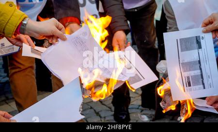 Izmir, Turchia. 14th Jan 2022. La piattaforma Izmir della KESK (Confederazione dei sindacati dei dipendenti pubblici) ha protestato contro l'alto tasso di inflazione in Turchia e ha gridato: "Non possiamo sopravvivere, vogliamo salari sufficienti per una vita umana!” La piattaforma ha evidenziato la differenza tra i calcoli dell'Istituto statistico turco (TUIK) e del Gruppo di ricerca sull'inflazione (ENAG). Dopo il comunicato stampa, hanno bruciato i loro libri paga in dimostrazione per protestare le loro difficoltà finanziarie da aumento dei prezzi di elettricità, gas naturale, combustibile, trasporto e cibo. Credit: İdil Toffolo/Alamy Live News Foto Stock