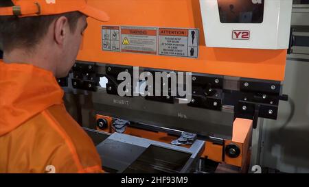 Piegatrice per operatore di lamiere mediante piegatrice per lamiere, piegatrice per lamiere ad alta precisione. Clip. L'operatore tecnico utilizza Foto Stock