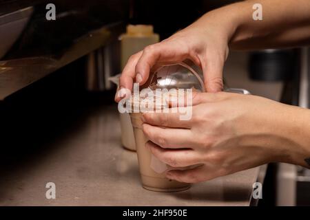 Il barista della caffetteria prepara una bevanda ghiacciata per un cliente Foto Stock