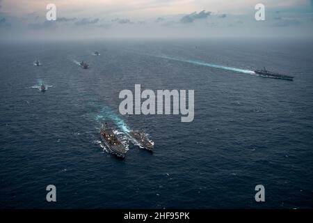 220113-N-HS181-1268 SOUTH CHINA SEA (GEN. 13, 2022) da sinistra, Harpers nave portuale di classe traghetto USS Pearl Harbor (LSD 52), cacciatorpediniere missilistico guidato di classe Arleigh Burke USS o’Kane (DDG 77), molo di atterraggio per elicotteri di classe Wasp USS Essex (LHD 2), nave da carico a secco di classe Lewis e Clark USNS Alan Shephard (T-AKE 3), flotta Henry J. (T-AO 194), il cacciatorpediniere missilistico guidato di classe Arleigh Burke USS Michael Murphy (DDG 112), l'incrociatore missilistico guidato di classe Ticonderoga USS Lake Champlain, e il vettore aereo di classe Nimitz USS Carl Vinson (CVN 70) transitano il Foto Stock