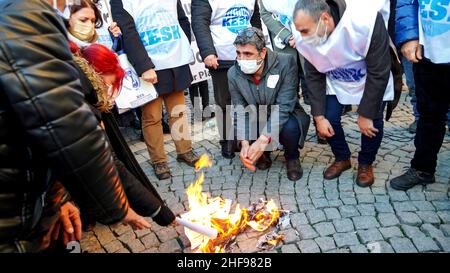 Izmir, Izmir, Turchia. 14th Jan 2022. La piattaforma Izmir della KESK (Confederazione dei sindacati dei dipendenti pubblici) ha protestato contro l'alto tasso di inflazione in Turchia e ha gridato: "Non possiamo sopravvivere, vogliamo salari sufficienti per una vita umana!" La piattaforma ha evidenziato la differenza tra i calcoli dell'Istituto statistico turco (TUIK) e del Gruppo di ricerca sull'inflazione (ENAG). Dopo il comunicato stampa, hanno bruciato i loro libri paga in dimostrazione per protestare le loro difficoltà finanziarie da aumento dei prezzi di elettricità, gas naturale, combustibile, trasporto e cibo. (Credit Image: © Idil Toffolo/Pa Foto Stock