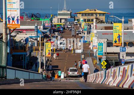 I deliverymen forniscono i commercianti locali presto il sabato mattina sul molo di Santa Monica mentre i gruppi turistici in anticipo arrivano. Foto Stock