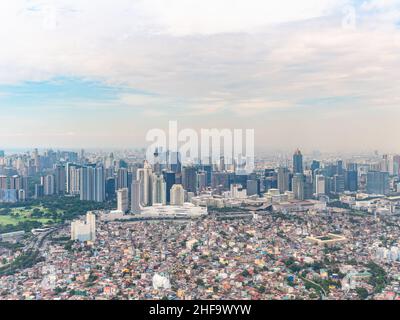 Foto aerea delle aree residenziali di Pembo, Metro Manila, con Bonifacio Global City con le sue sfarzose aree commerciali e l'elegante edificio alto Foto Stock