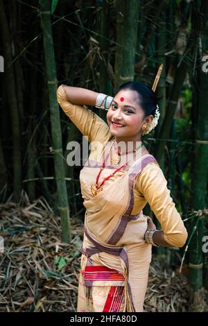 ragazza in danza spostare isolato vestito in tradizionale indossare in festival con immagine di sfondo sfocata è preso in occasione del bihu ad assam india. Foto Stock